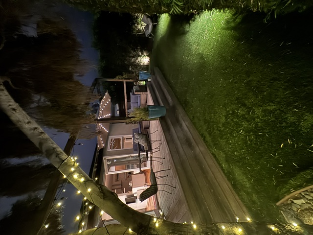 Private garden and patio illuminated by warm string lights at night